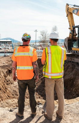 men-in-safety-vests-standing-in-front-of-a-construction-vehicle.jpg men in safety vests standing in front of a construction vehicle
